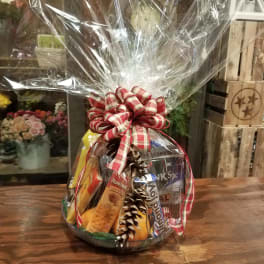 Gift basket of snacks wrapped in clear cellophane with a red plaid bow