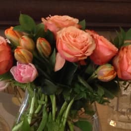 Bouquet of peach and pink roses in a clear glass vase