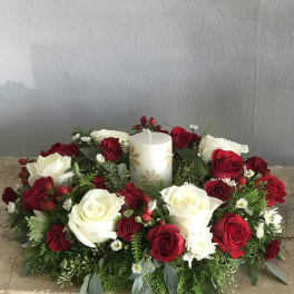 Red and white rose centerpiece with a white pillar candle