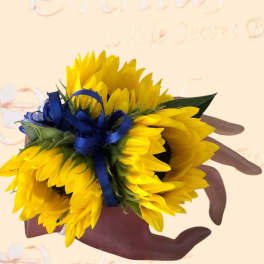 Handheld bouquet of bright yellow sunflowers tied with a blue ribbon