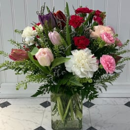 Mixed bouquet of tulips and carnations in a glass vase