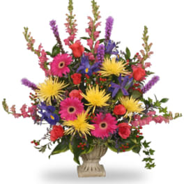 Colorful mixed flower arrangement in a stone urn vase