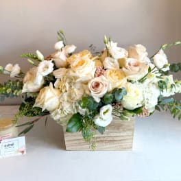 Cream and white rose arrangement in a wooden box with eucalyptus