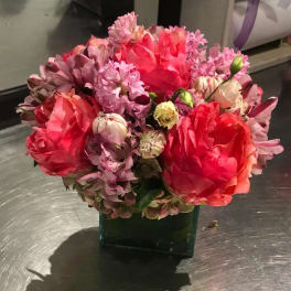 Pink and red mixed bouquet in a square glass vase