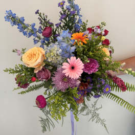 Colorful mixed bouquet with roses, gerbera daisies, and blue delphinium