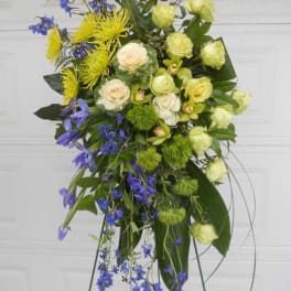 Tall floral spray with yellow, white, and blue flowers on a stand