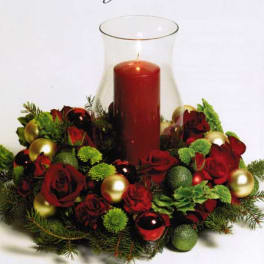 Red rose centerpiece with a tall red candle in a glass hurricane vase