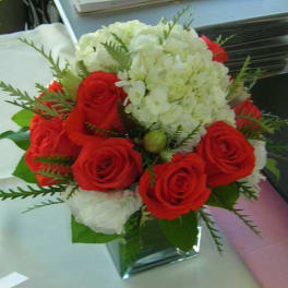 Red roses and white hydrangeas in a clear glass vase