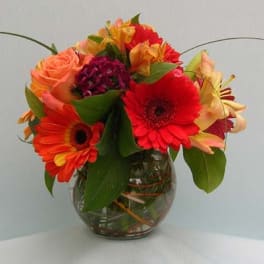 Mixed bouquet of gerbera daisies and roses in a glass vase