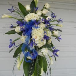 Tall floral spray with white roses, hydrangeas, and blue accents