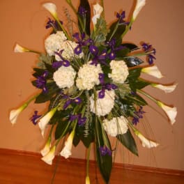 Tall floral standing spray with white calla lilies and purple flowers