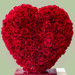 Heart-shaped arrangement of red roses on a pedestal