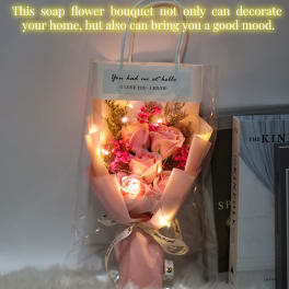 Pink rose bouquet wrapped in pastel paper with string lights