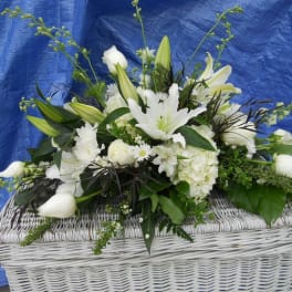 White floral arrangement in a white wicker basket