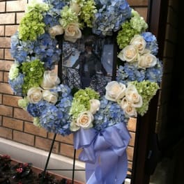 Blue and green floral wreath with cream roses on a stand