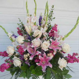 Tall floral arrangement with pink lilies, white roses, and purple accents