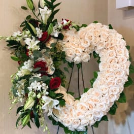 Heart-shaped floral wreath of cream roses with red and white lilies