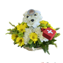 Yellow and white flower basket with a teddy bear and red first-aid kit