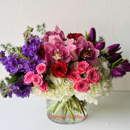 Bouquet of pink and purple flowers in a clear glass vase