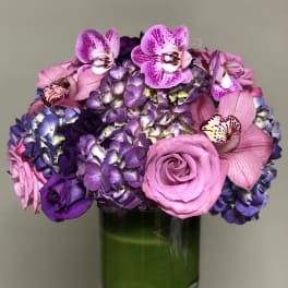 Pink and purple bouquet in a green glass vase