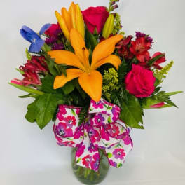 Colorful mixed bouquet with lilies, roses, and alstroemeria in a glass vase
