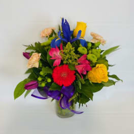 Colorful mixed bouquet in a glass vase with ribbon