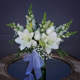 White lily bouquet with snapdragons in a glass vase and lavender ribbon