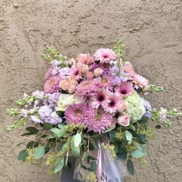 Pink and lavender bouquet with roses and daisies in a ribbon-tied arrangement