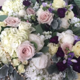 Bouquet of pale roses, white hydrangeas, and purple flowers