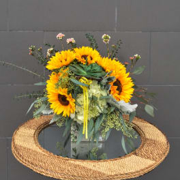 Sunflower bouquet with pale hydrangea and eucalyptus in a glass vase