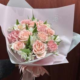 Pink rose and carnation bouquet wrapped in pale paper