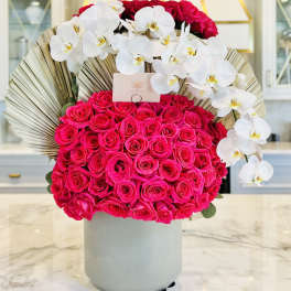 Hot pink roses with white orchids in a gray vase