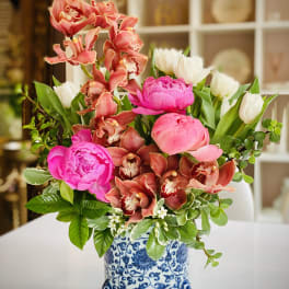 Pink peonies and orchids in a blue-and-white ceramic vase