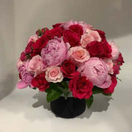 Bouquet of red and pink roses in a black vase