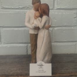 Wooden figurine of a couple holding a baby
