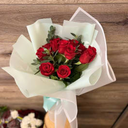 Bouquet of red roses wrapped in white paper