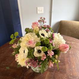 Mixed bouquet of pink and white flowers in a clear glass vase