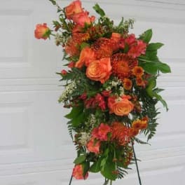 Tall orange floral standing spray on an easel