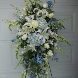 Tall standing floral spray with white lilies and blue hydrangeas
