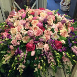 Large pink and purple floral arrangement with roses and orchids
