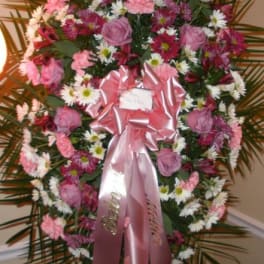 Pink and white floral standing spray with a pink ribbon
