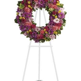 Colorful floral wreath on a white easel stand