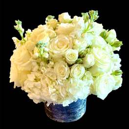 White rose and hydrangea arrangement in a blue textured vase