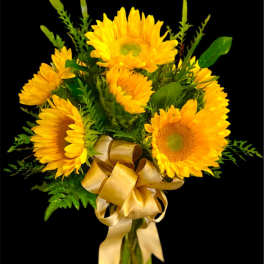 Bouquet of yellow sunflowers with a gold ribbon in a glass vase