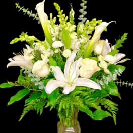 White lilies and roses arranged in a glass vase
