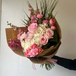 Pink and white mixed bouquet wrapped in brown paper