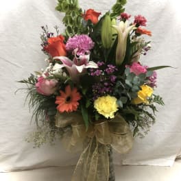 Mixed bouquet in a glass vase with lilies, roses, and gerbera daisies