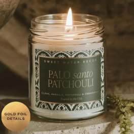 Lit scented candle in a glass jar with a decorative label