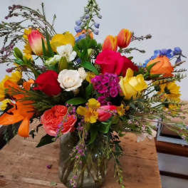 Colorful mixed bouquet in a glass vase with roses and tulips