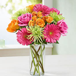 Pink and orange mixed bouquet in a clear glass vase